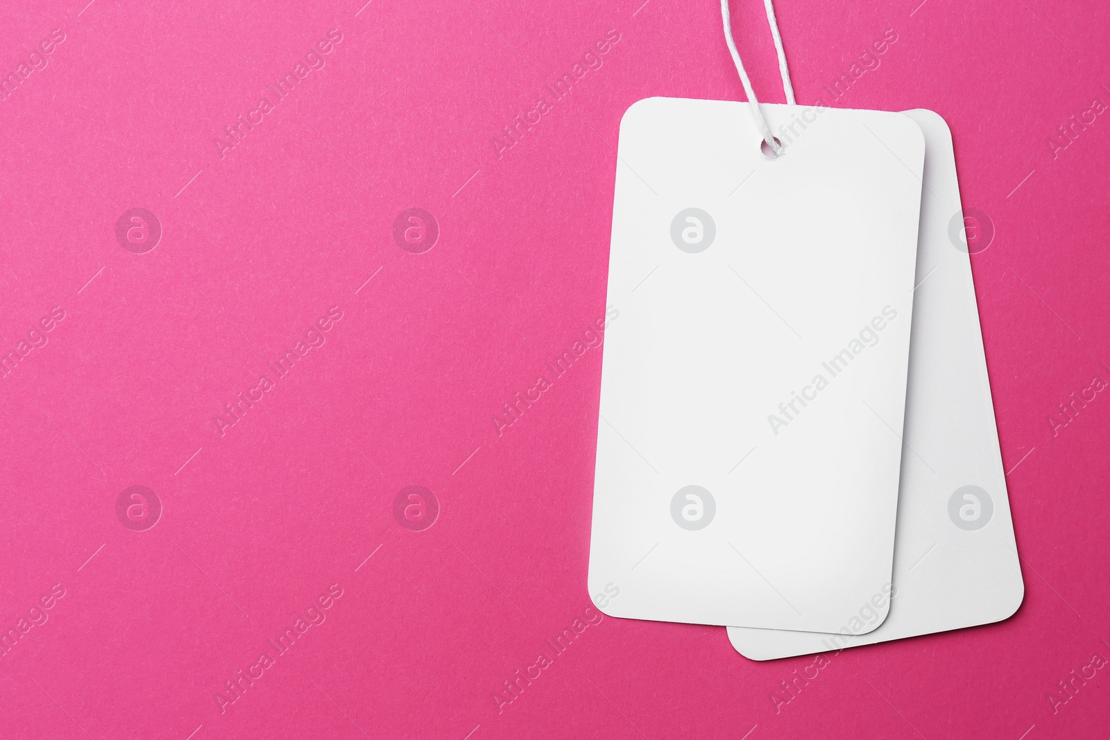 Photo of Tags with space for text on pink background, top view