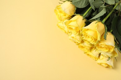 Beautiful bouquet of yellow roses on beige background, top view. Space for text