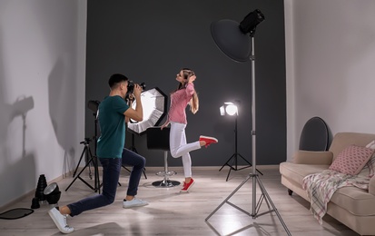 Beautiful young model posing for professional photographer in studio