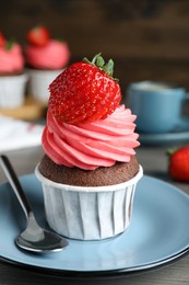 Photo of Sweet cupcake with fresh strawberry on plate, closeup