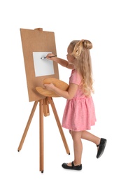 Child painting picture on easel against white background. Space for text