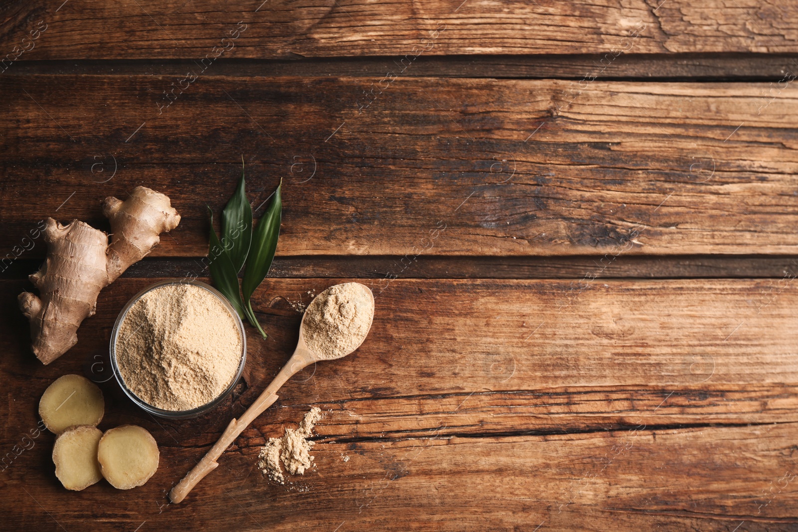 Photo of Dry ginger powder, fresh root and leaves on wooden table, flat lay. Space for text