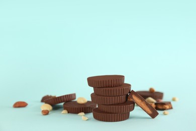 Photo of Sweet peanut butter cups on turquoise background. Space for text