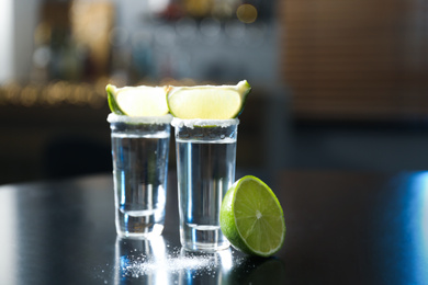 Mexican Tequila with salt and lime slices on black table at bar