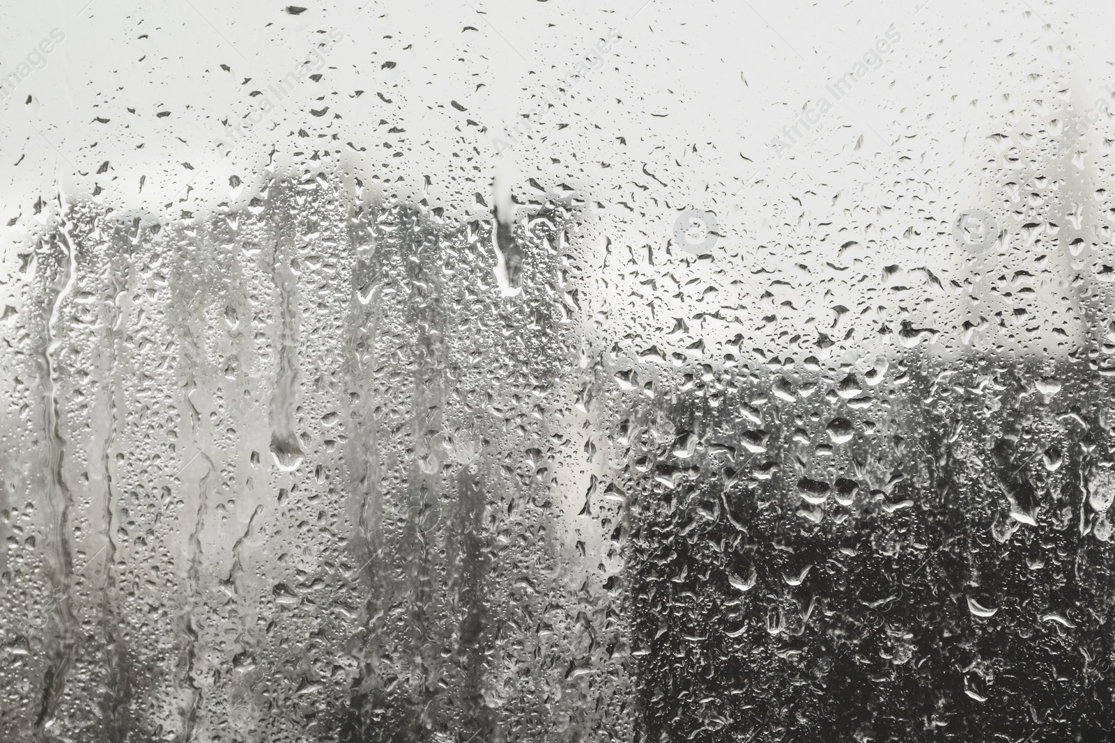 Photo of Blurred view of city from window on rainy day