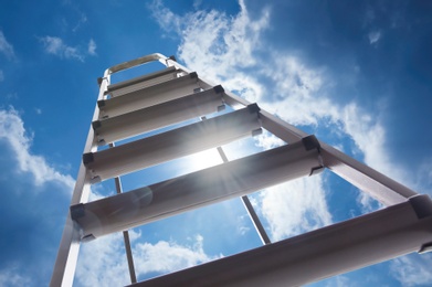 Image of Metal stepladder against blue sky with clouds, low angle view
