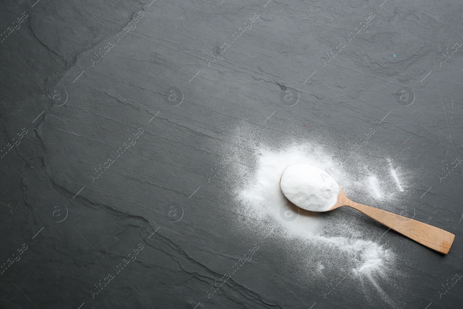 Photo of Baking soda on black table, top view. Space for text