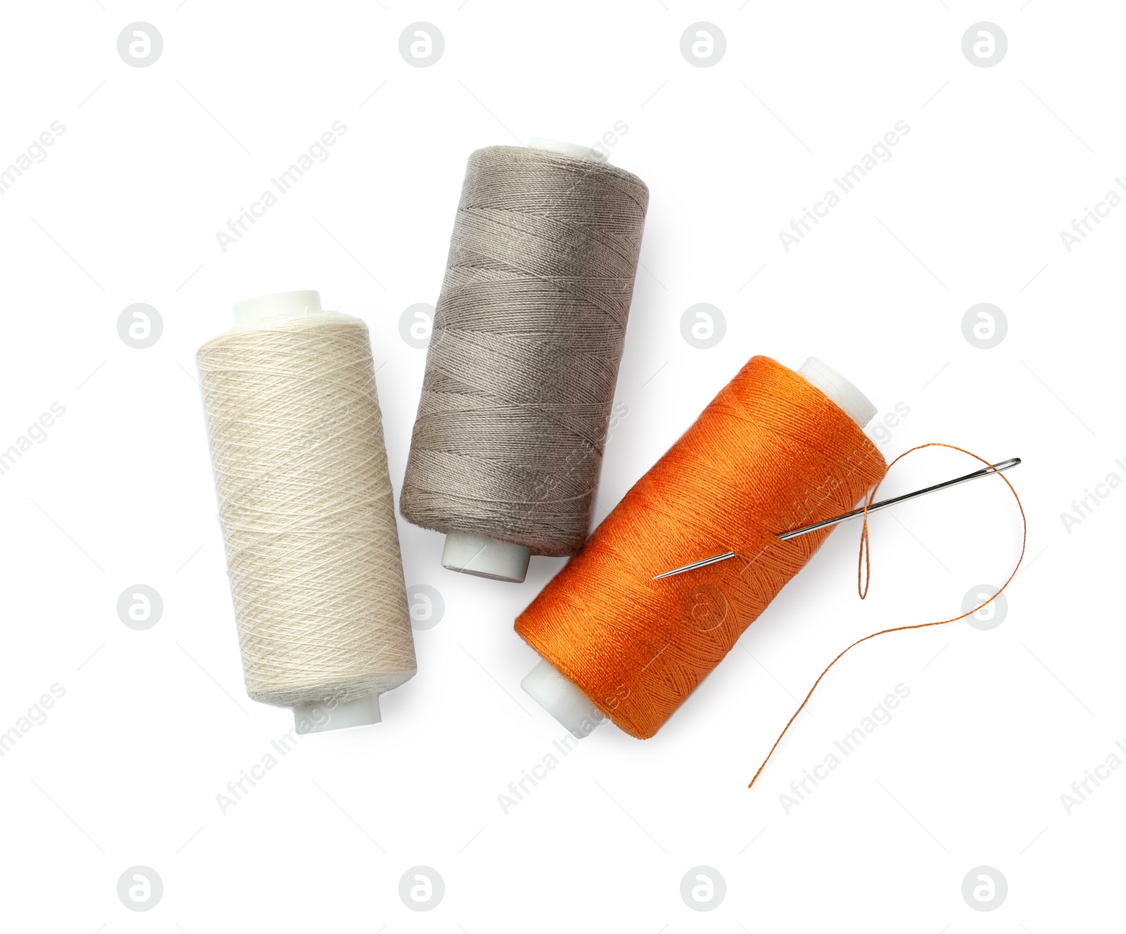 Photo of Different colorful sewing threads and needle on white background, top view