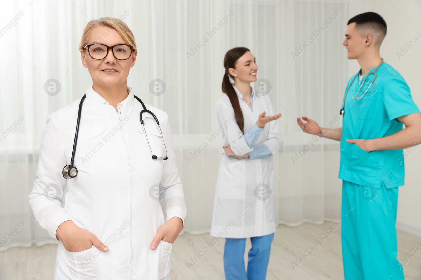 Photo of Portrait of doctor near colleagues in clinic