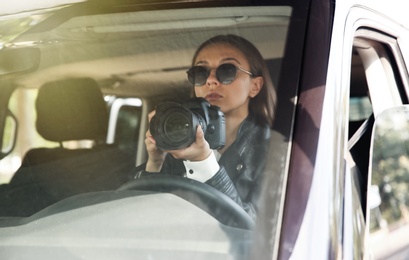 Private detective with camera spying from car