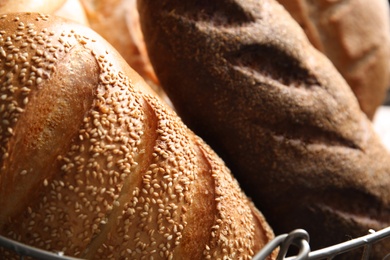 Photo of Different kinds of fresh bread in basket, closeup
