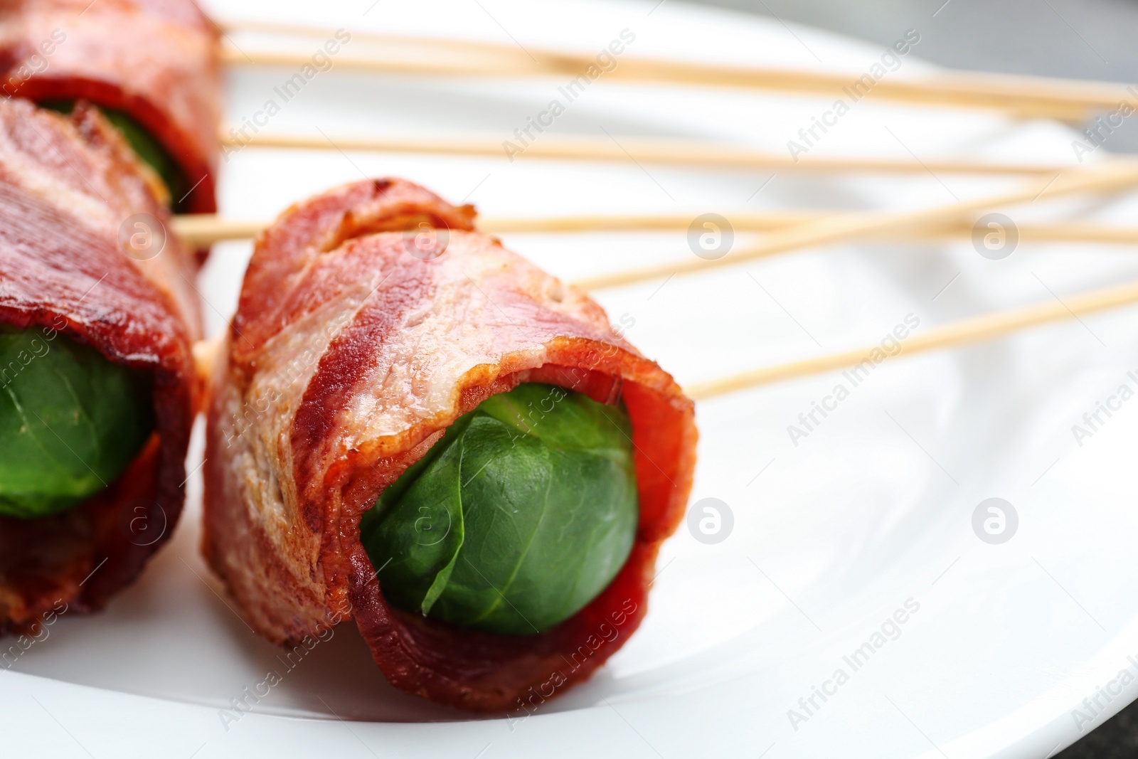 Photo of Plate with Brussels sprouts wrapped in bacon, closeup