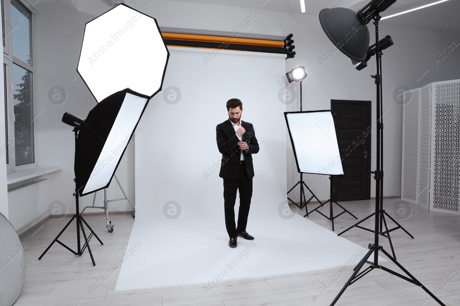 Photo of Handsome model posing in modern studio. Professional photo session