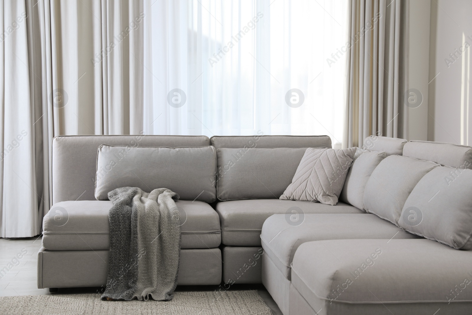 Photo of Large grey sofa in living room. Interior design