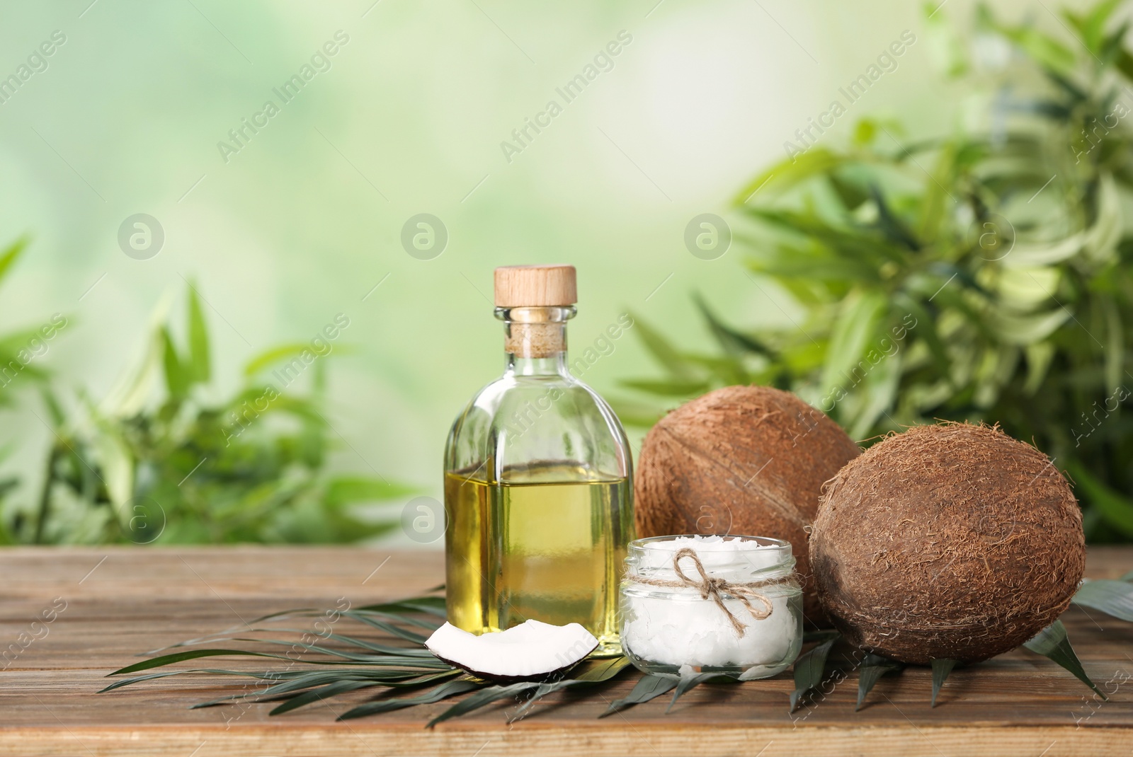 Photo of Composition with natural organic coconut oil on wooden table. Space for text