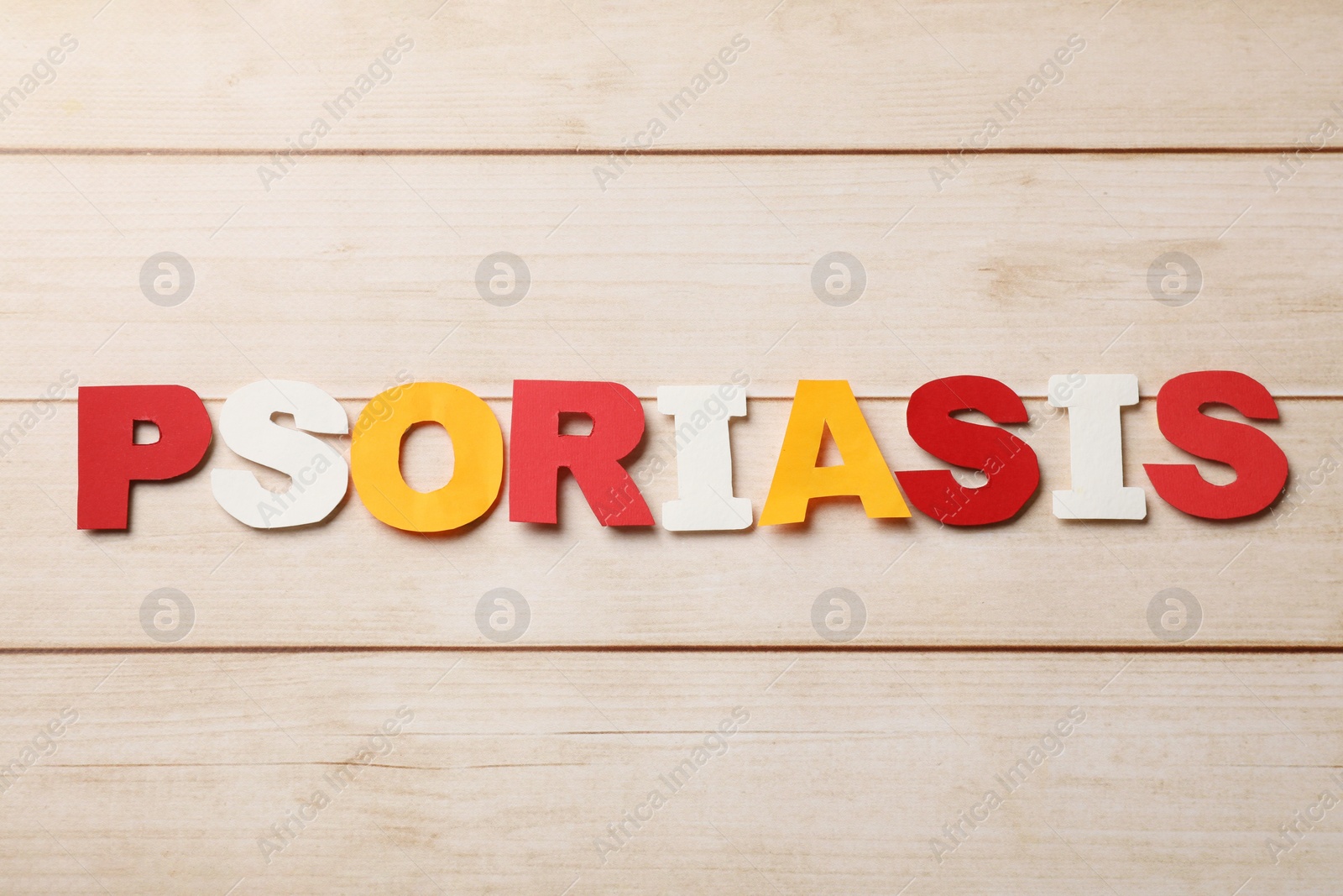 Photo of Word Psoriasis made of paper letters on wooden table, top view