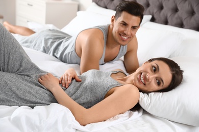 Photo of Portrait of lovely young couple resting in large bed