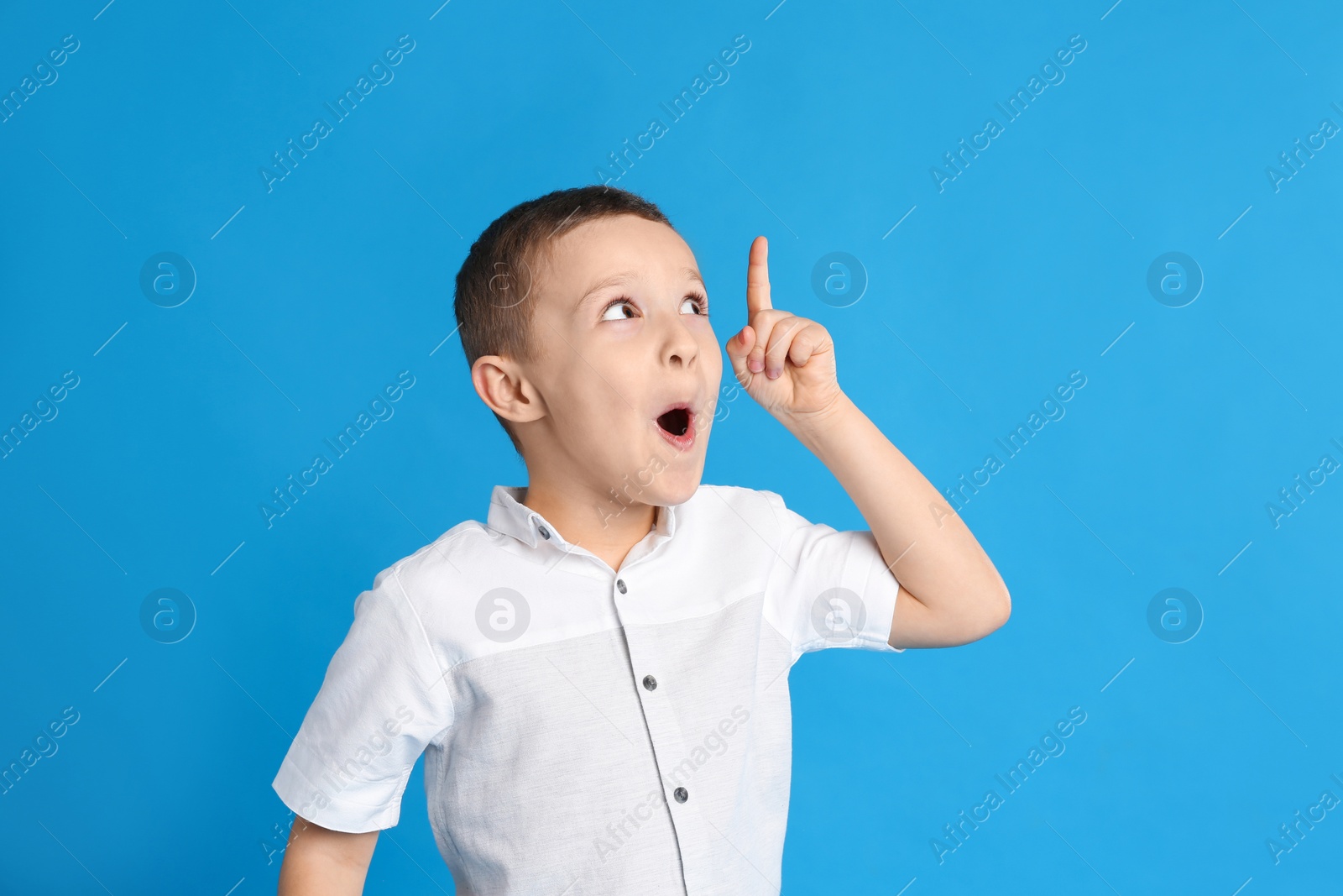 Photo of Portrait of emotional little boy on blue background