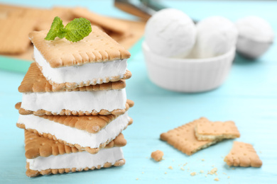 Photo of Sweet delicious ice cream cookie sandwiches on light blue wooden table, closeup. Space for text