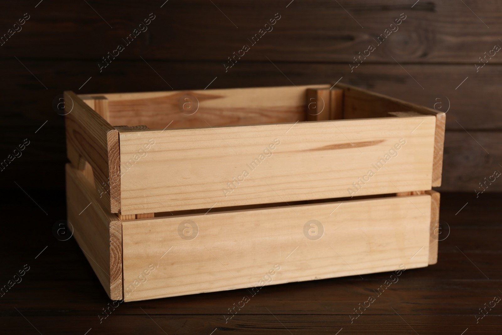 Photo of Empty crate on table against wooden background