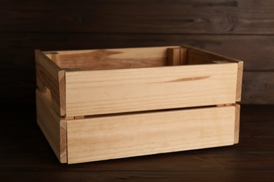 Photo of Empty crate on table against wooden background