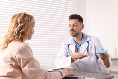 Photo of Doctor consulting patient at table in clinic