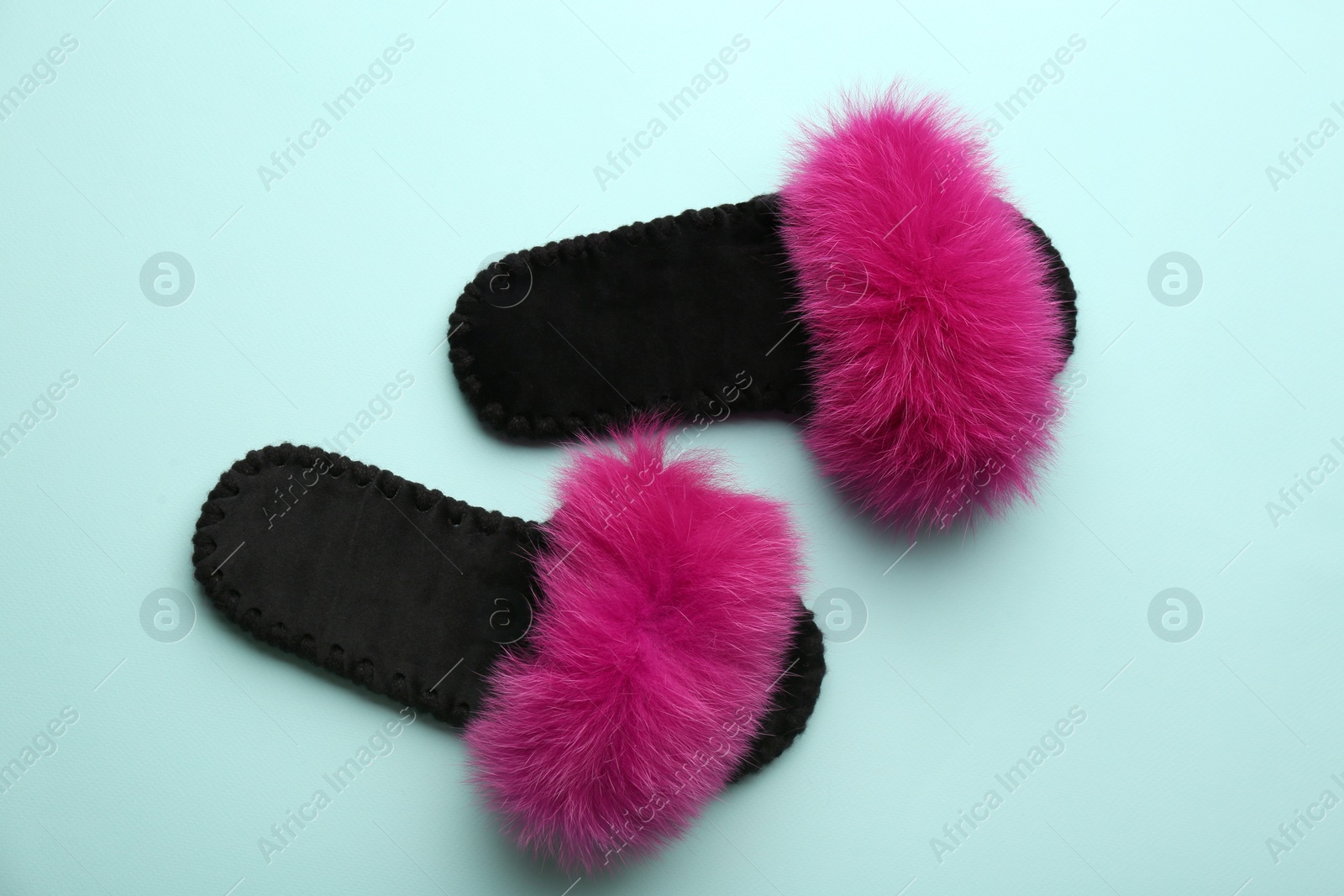 Photo of Pair of soft slippers on light blue background, flat lay