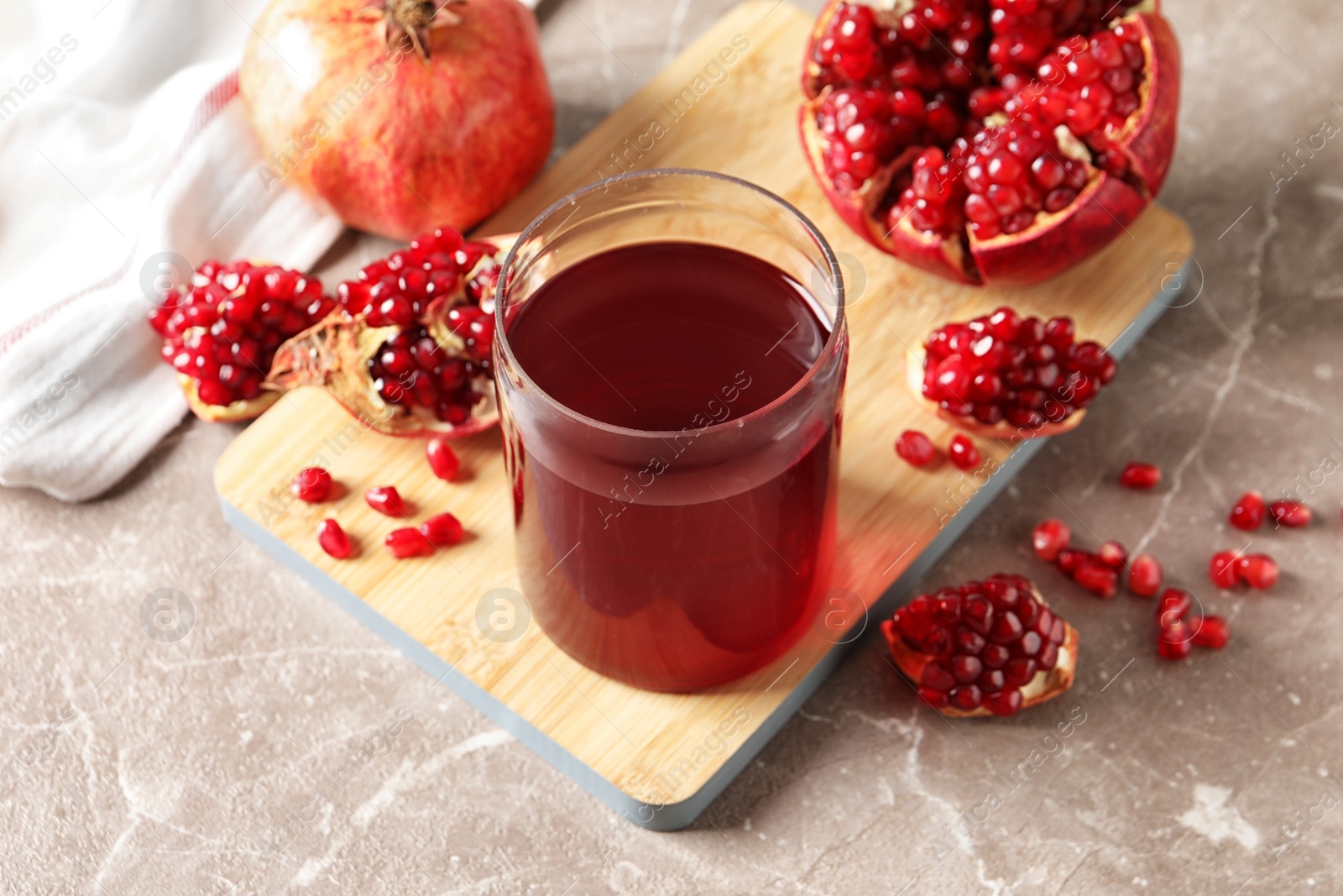 Photo of Composition with glass of fresh pomegranate juice on table