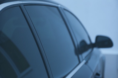 Photo of Modern car with tinting foil on window, closeup