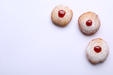 Photo of Hanukkah donuts with jelly and powdered sugar on white background, flat lay. Space for text