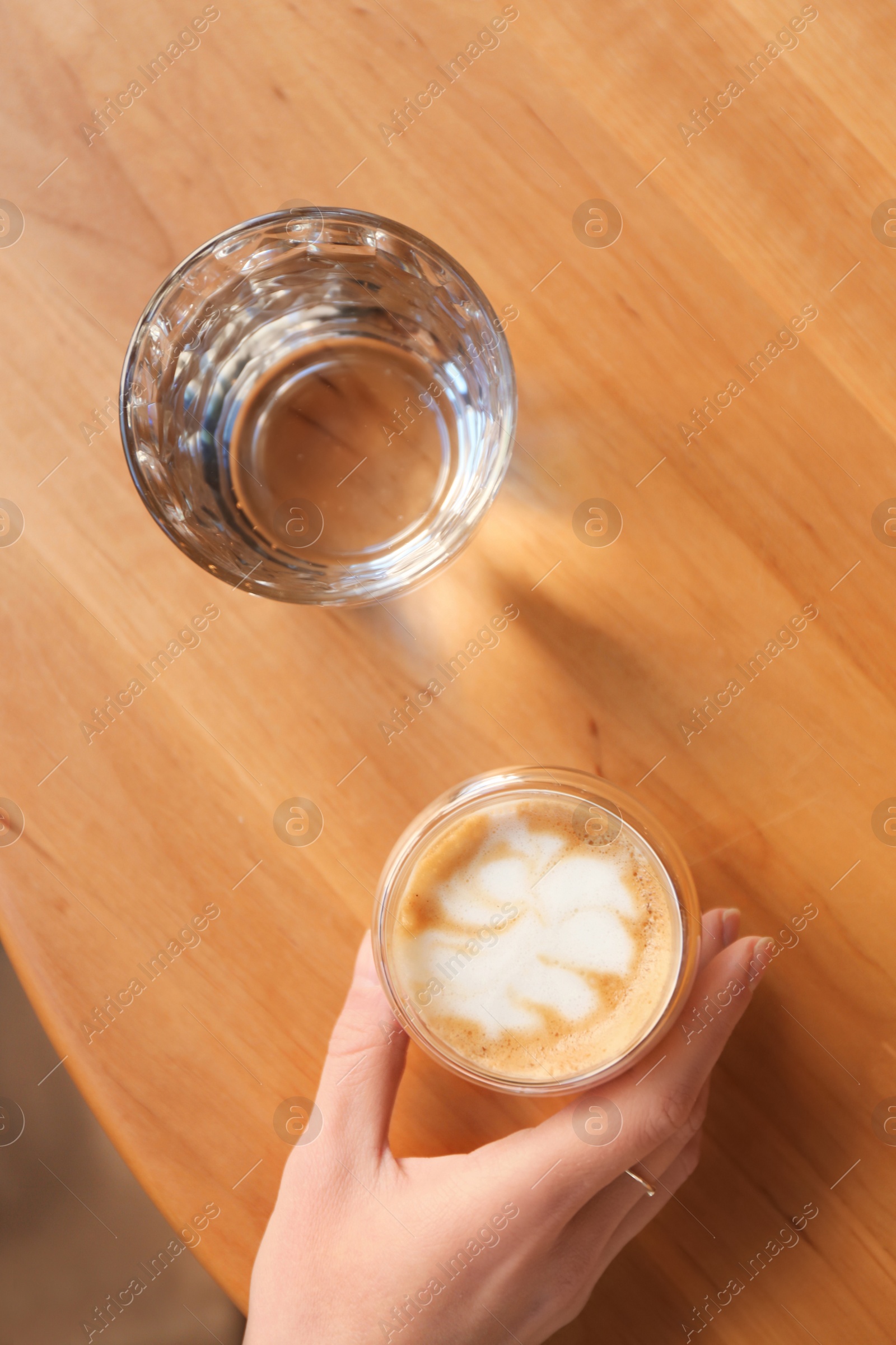 Photo of Woman with aromatic coffee at table in cafe, top view