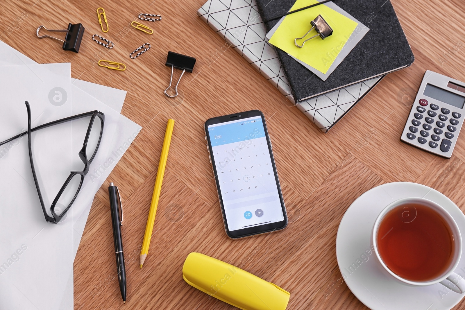 Photo of Smartphone with calendar app on wooden table, above view