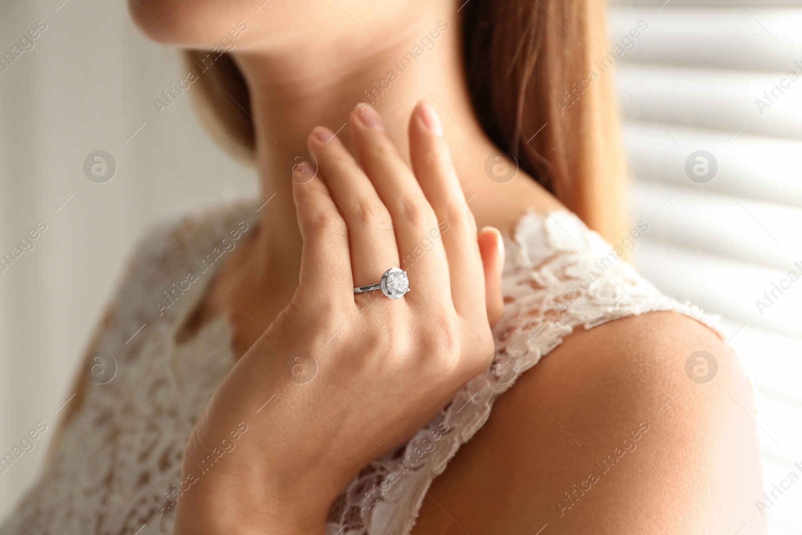 Photo of Young bride wearing beautiful engagement ring, closeup