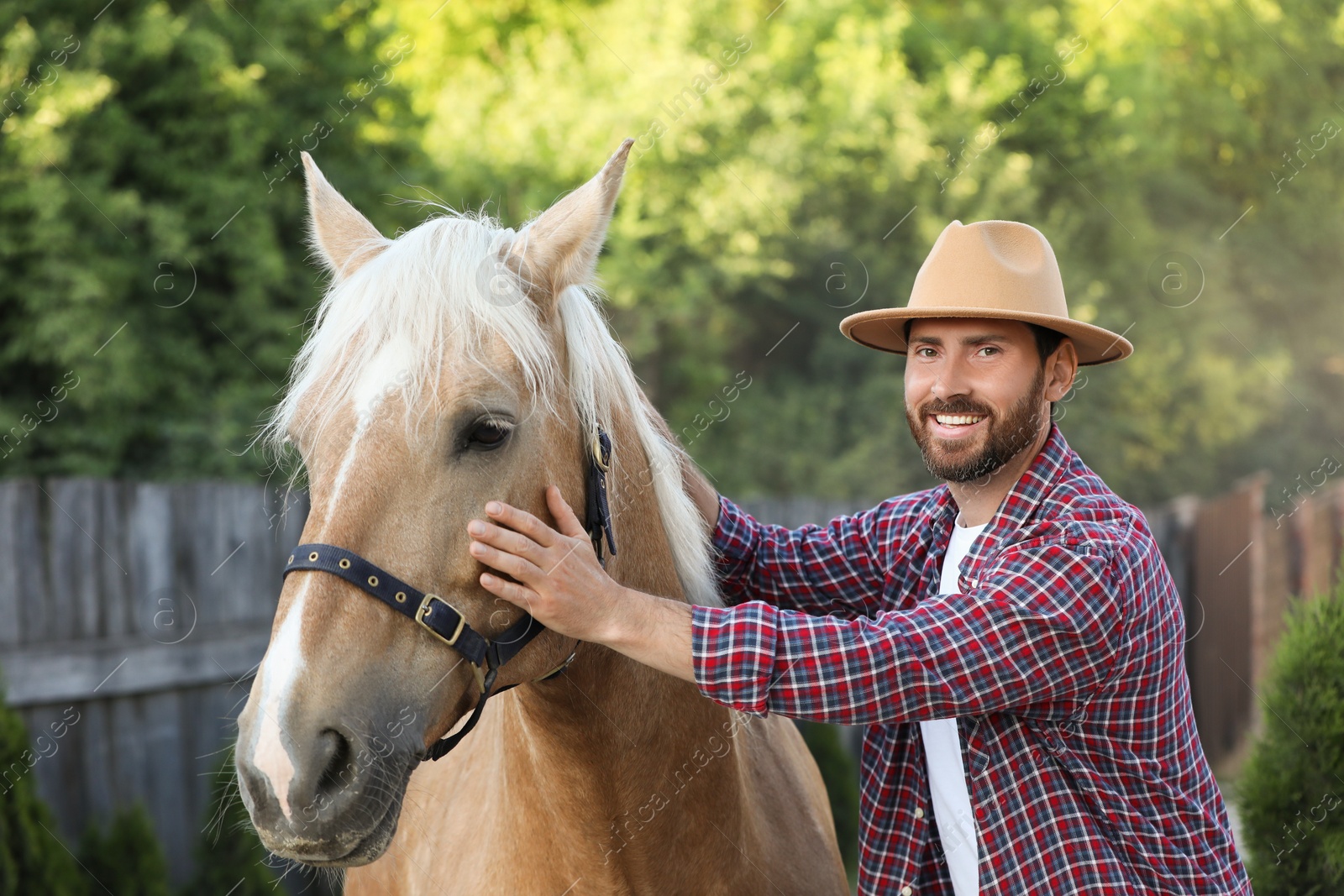 Photo of Handsome man with adorable horse outdoors. Lovely domesticated pet