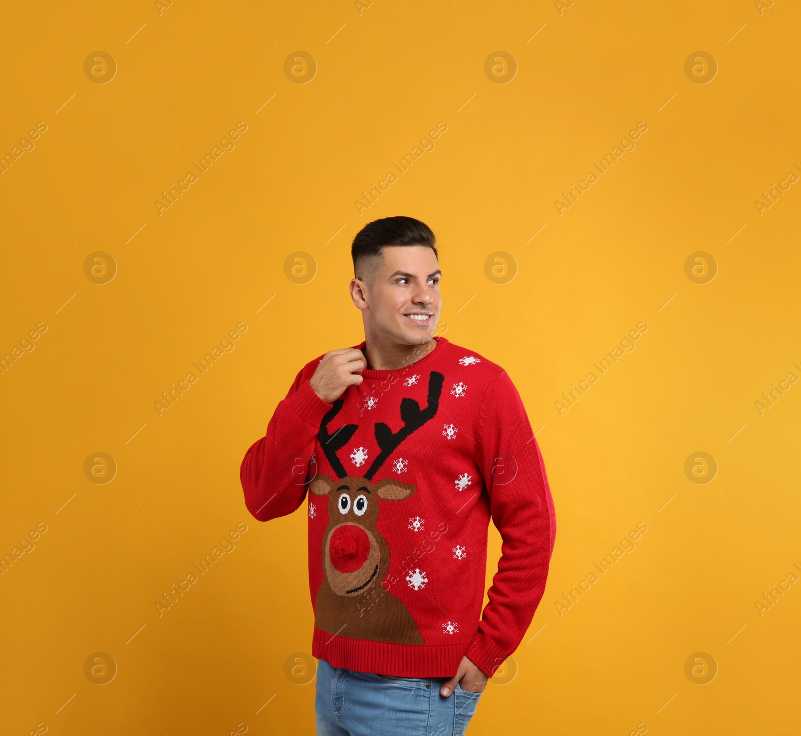 Photo of Handsome man in Christmas sweater on yellow background