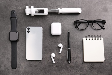 Photo of Flat lay composition with stylish smart watch on grey stone table