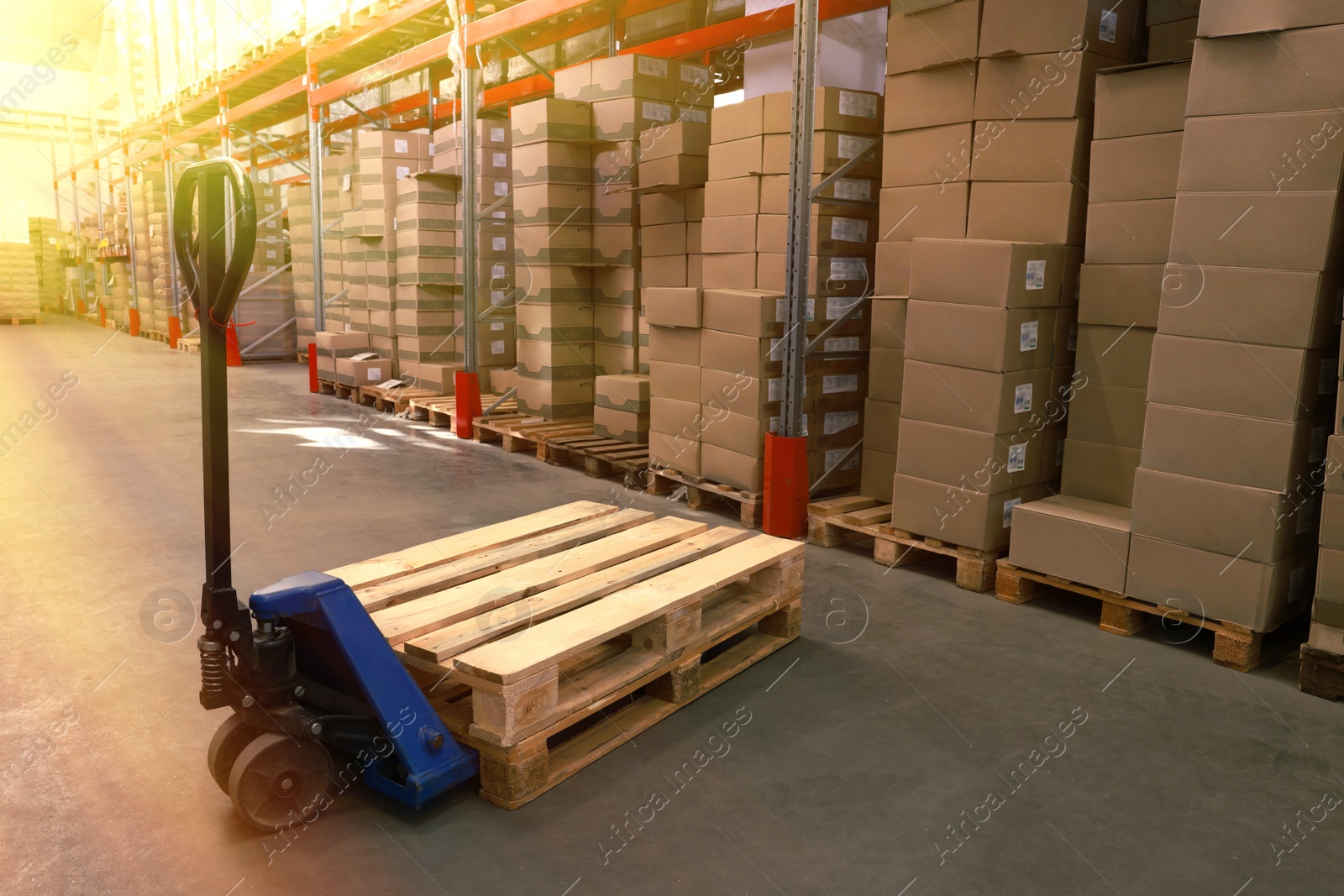 Image of Modern manual forklift with wooden pallets in warehouse