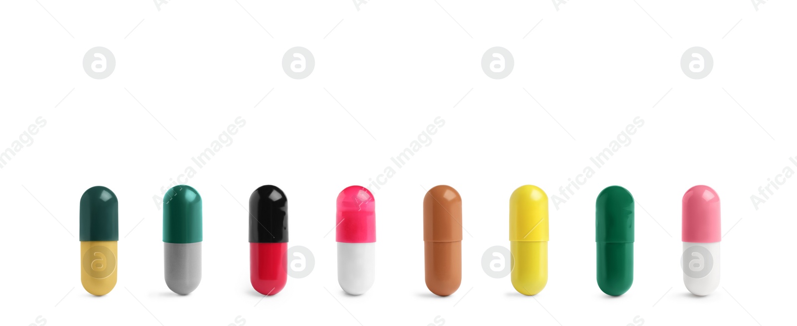 Image of Set of different color pills in row isolated on white