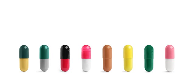Image of Set of different color pills in row isolated on white