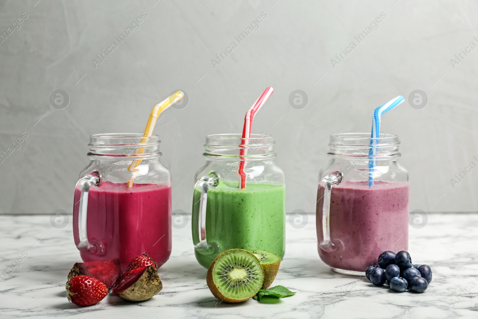 Photo of Mason jars with healthy detox smoothies and ingredients on table