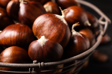 Photo of Fresh sweet edible chestnuts in basket, closeup