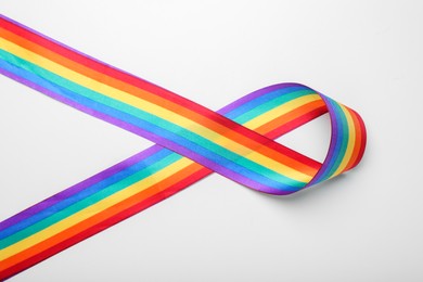 Photo of Rainbow ribbon on white background, top view. LGBT pride