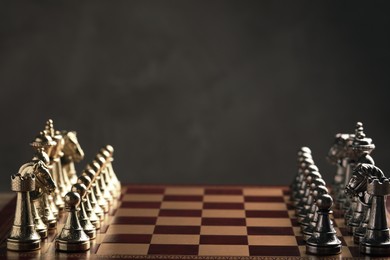 Photo of Chessboard with game pieces on grey background. Space for text