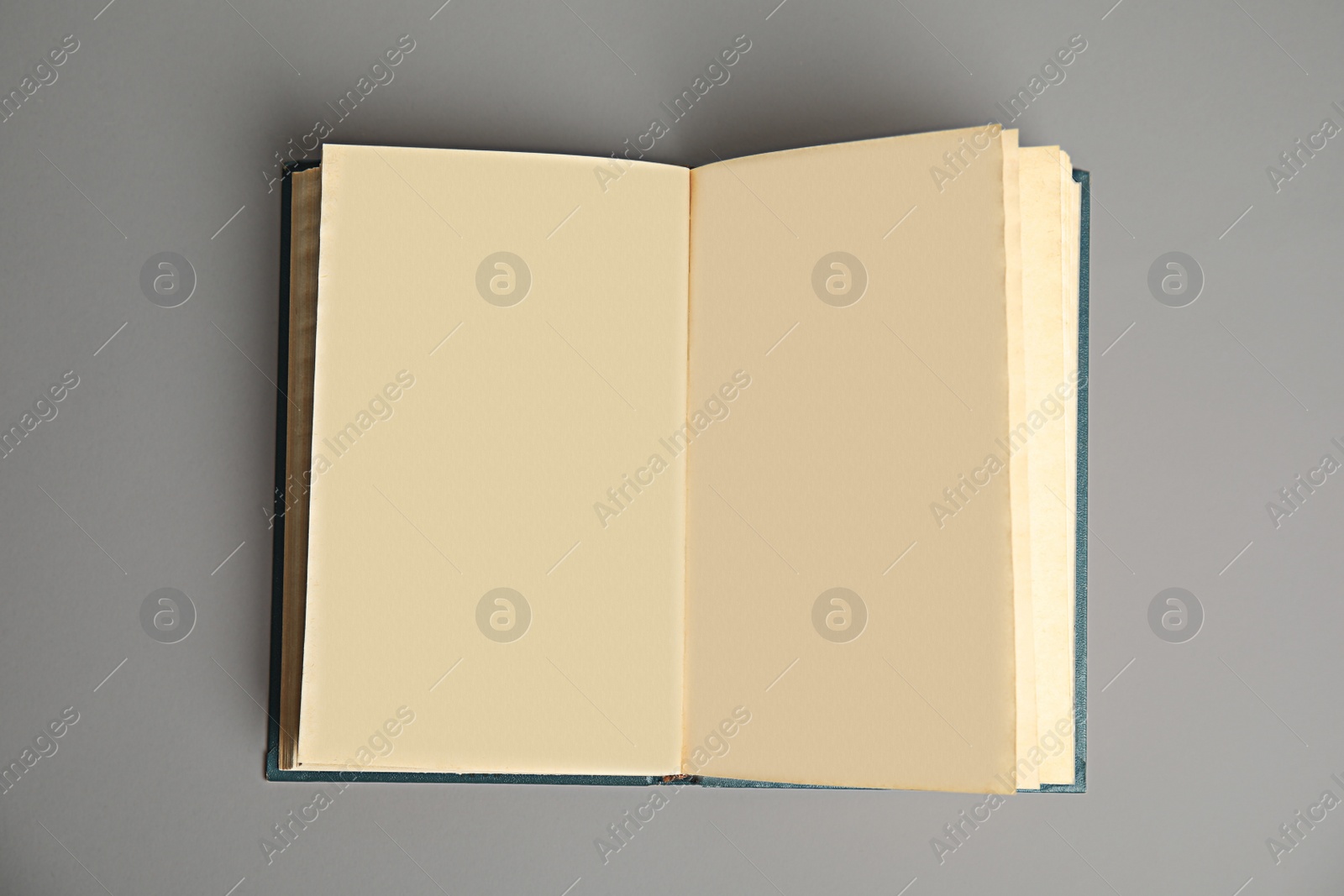 Photo of Open book on light grey background, top view. Space for text