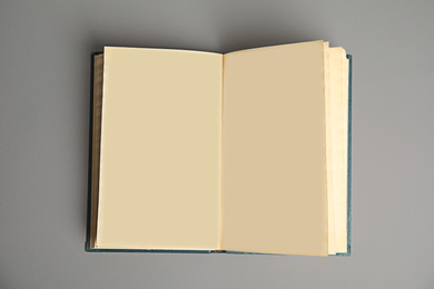 Open book on light grey background, top view. Space for text