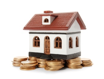 Photo of House model and coins on white background. Heating price concept