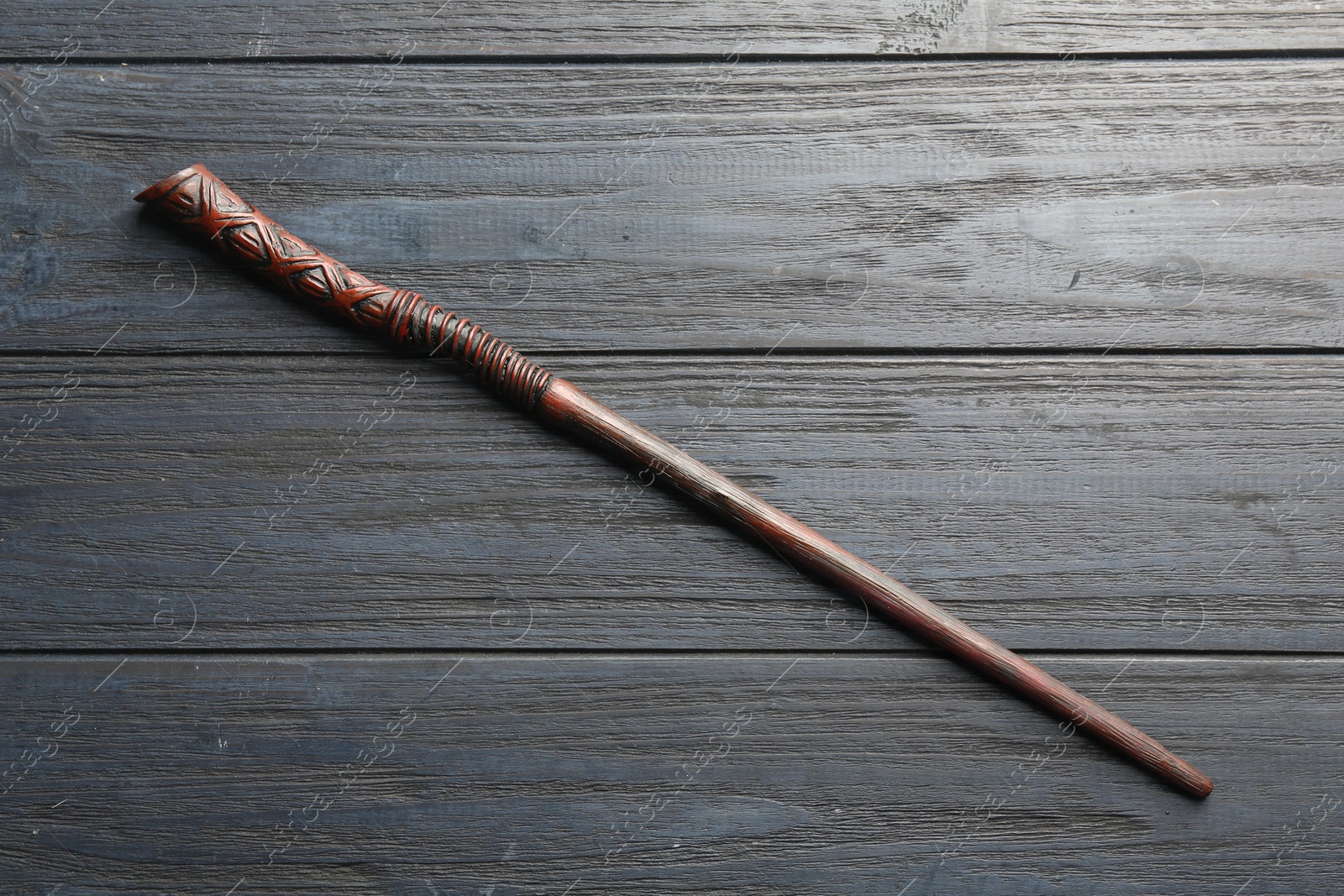 Photo of One old magic wand on grey wooden table, top view