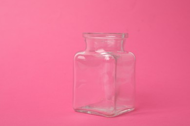 Photo of Open empty glass jar on pink background