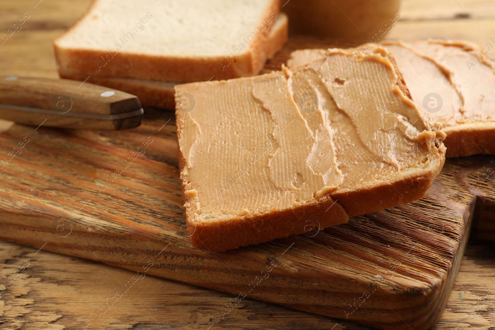 Photo of Tasty peanut butter sandwiches on wooden table, closeup view