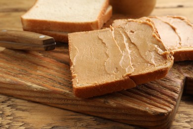 Photo of Tasty peanut butter sandwiches on wooden table, closeup view